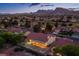 Stunning aerial view of a well-lit home with a covered patio in a scenic neighborhood with mountain views at dusk at 2740 Billy Casper Dr, Las Vegas, NV 89134