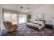 Bright bedroom with a ceiling fan, patterned rug, accent chair, and sliding door to the outdoor space at 2740 Billy Casper Dr, Las Vegas, NV 89134