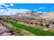 Scenic view of the golf course and surrounding neighborhood with mature trees and beautiful mountain backdrop at 2740 Billy Casper Dr, Las Vegas, NV 89134