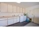 A large laundry room with sink, cabinetry, and modern washer and dryer at 2740 Billy Casper Dr, Las Vegas, NV 89134