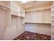Spacious walk-in closet featuring custom shelves and an interesting patterned carpet at 2740 Billy Casper Dr, Las Vegas, NV 89134