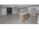 Open-concept kitchen with large island flowing into a living area with a stone fireplace at 2905 Dogwood Ct, North Las Vegas, NV 89030