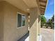 Covered porch with stucco facade and lush landscaping beyond at 3016 Mount Charleston Dr, Pahrump, NV 89048