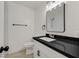 Modern bathroom featuring a black speckled granite countertop and white cabinets with a framed mirror at 3124 Glenhurst Dr, Las Vegas, NV 89121