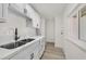Bright kitchen with white cabinets, stainless steel sink, marble countertops, and wood-style flooring at 3124 Glenhurst Dr, Las Vegas, NV 89121