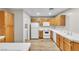 Bright kitchen features wood cabinets, white appliances, and laminate flooring at 3676 Renovah St # 102, Las Vegas, NV 89129