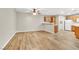 Open-concept living area with modern wood floors that flow into kitchen and laundry area at 3676 Renovah St # 102, Las Vegas, NV 89129