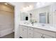 Bright bathroom with dual sinks, a large mirror, and a tub with shower at 3846 W Neal Ave, Las Vegas, NV 89141