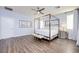 Light-filled bedroom with modern four-poster bed and wood-look flooring at 3846 W Neal Ave, Las Vegas, NV 89141