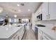 Open kitchen with stainless appliances, quartz countertops, and a view of the living and dining areas at 3846 W Neal Ave, Las Vegas, NV 89141