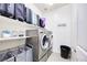 A well-organized laundry room with modern washer and dryer, storage shelves, and stylish decor at 3846 W Neal Ave, Las Vegas, NV 89141