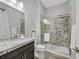Modern bathroom features a granite countertop vanity with dark cabinets and sleek shower with glass door at 3870 Valles Caldera Ct, Las Vegas, NV 89118