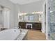 Elegant bathroom with granite counters, dual sinks, tub, glass enclosed shower and wood-look tile floor at 3870 Valles Caldera Ct, Las Vegas, NV 89118