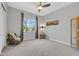 Bedroom featuring a ceiling fan, carpeted floor, and large window at 3870 Valles Caldera Ct, Las Vegas, NV 89118