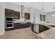 Modern kitchen featuring stainless steel appliances, dark cabinets, and a granite-topped island with a sink at 3870 Valles Caldera Ct, Las Vegas, NV 89118