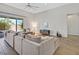 Bright living room showcasing a comfortable sectional couch and sliding glass doors to the backyard patio at 3870 Valles Caldera Ct, Las Vegas, NV 89118