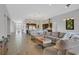 Open-concept living room with tile floors, a large sectional, and views of the kitchen and entry at 3870 Valles Caldera Ct, Las Vegas, NV 89118