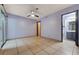 Spacious bedroom featuring light purple walls, tile flooring, ceiling fan, and ensuite bathroom access at 441 N Lamb Blvd # E, Las Vegas, NV 89110