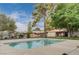 Relaxing pool surrounded by mature trees, landscaping, and fencing at 441 N Lamb Blvd # E, Las Vegas, NV 89110