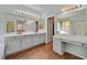 Well-lit bathroom features double sinks, vanity, and walk-in closet entrance with wood-look tile floors at 4432 Vicobello Ave, Las Vegas, NV 89141