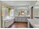 Bathroom featuring a large soaking tub, double sinks, and stylish fixtures at 4432 Vicobello Ave, Las Vegas, NV 89141