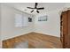 Bedroom with wood-look floors, a ceiling fan, and a window for natural light at 4432 Vicobello Ave, Las Vegas, NV 89141