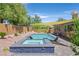 A backyard swimming pool and elevated hot tub with mature landscaping create an inviting outdoor space at 4432 Vicobello Ave, Las Vegas, NV 89141