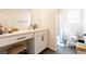 Well-lit bathroom features a vanity with a makeup counter and a shower behind a white shower curtain at 4707 Pink Jasper Ct, Las Vegas, NV 89141