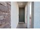 Inviting covered front porch with an olive-colored front door, stone accents, and brick-paved entryway at 4707 Pink Jasper Ct, Las Vegas, NV 89141