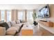 Inviting living room with a large sectional, modern media console, and herringbone wood floors at 4707 Pink Jasper Ct, Las Vegas, NV 89141