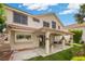 Backyard with a covered patio, lush green lawn, and mature trees, perfect for outdoor living at 5148 Forest Oaks Dr, Las Vegas, NV 89149