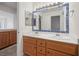Bathroom featuring double sink vanity with framed mirror, drawers, and cabinet storage at 5148 Forest Oaks Dr, Las Vegas, NV 89149