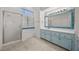 Bright bathroom with a glass-enclosed shower, soaking tub, and blue accent tiles at 5148 Forest Oaks Dr, Las Vegas, NV 89149