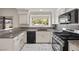 Bright kitchen featuring granite countertops, modern appliances, white cabinets, and tile backsplash at 5148 Forest Oaks Dr, Las Vegas, NV 89149