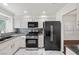 Modern kitchen boasts granite countertops, stainless steel appliances, white cabinets, and a stylish backsplash at 5148 Forest Oaks Dr, Las Vegas, NV 89149