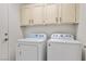Functional laundry room with washer, dryer, and ample cabinet space at 5148 Forest Oaks Dr, Las Vegas, NV 89149