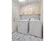 Functional laundry room with marble floors, upper cabinets, and essential appliances for efficient chore management at 5148 Forest Oaks Dr, Las Vegas, NV 89149