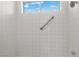 Clean, white-tiled shower with a grab bar and a window offering natural light at 5148 Forest Oaks Dr, Las Vegas, NV 89149