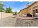 The backyard features ample gravel space, a patio dining set, and mature trees at 5224 Dana Springs Way, Las Vegas, NV 89130