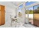 Bright dining area with white tile floors, a table with four chairs, and sliding glass doors leading to the backyard at 5224 Dana Springs Way, Las Vegas, NV 89130