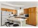 Kitchen with wood cabinets, white appliances, and breakfast bar at 5224 Dana Springs Way, Las Vegas, NV 89130