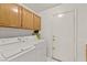Well-lit laundry room features modern washer and dryer and extra storage at 5224 Dana Springs Way, Las Vegas, NV 89130