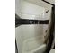 Tiled shower with black accent tiles and convenient in-wall niche shelving for storage at 5365 Shake Ct # 103, Las Vegas, NV 89122