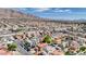 Panoramic view of a community with diverse homes, green trees, and a backdrop of scenic mountains at 5853 Calobar Ln, Las Vegas, NV 89110