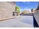 Side view of backyard revealing a spacious paved area, patio cover, block wall, and home's exterior at 5853 Calobar Ln, Las Vegas, NV 89110