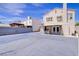 View of backyard showcasing an open paved area, patio cover, block wall, and access to the home's rear entrance at 5853 Calobar Ln, Las Vegas, NV 89110