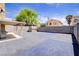 View of backyard displaying a spacious paved area, covered patio, storage shed, block wall, and ample space at 5853 Calobar Ln, Las Vegas, NV 89110
