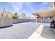 Spacious backyard featuring a covered patio, storage shed, privacy wall, and ample paved space for entertaining at 5853 Calobar Ln, Las Vegas, NV 89110