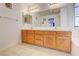 Bathroom with dual sinks, wooden cabinets, and large mirror at 5853 Calobar Ln, Las Vegas, NV 89110