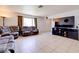 Spacious living area with tile flooring and neutral paint; large television for entertainment at 5853 Calobar Ln, Las Vegas, NV 89110